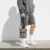 Kairos sling bag in grey carried by the top handle